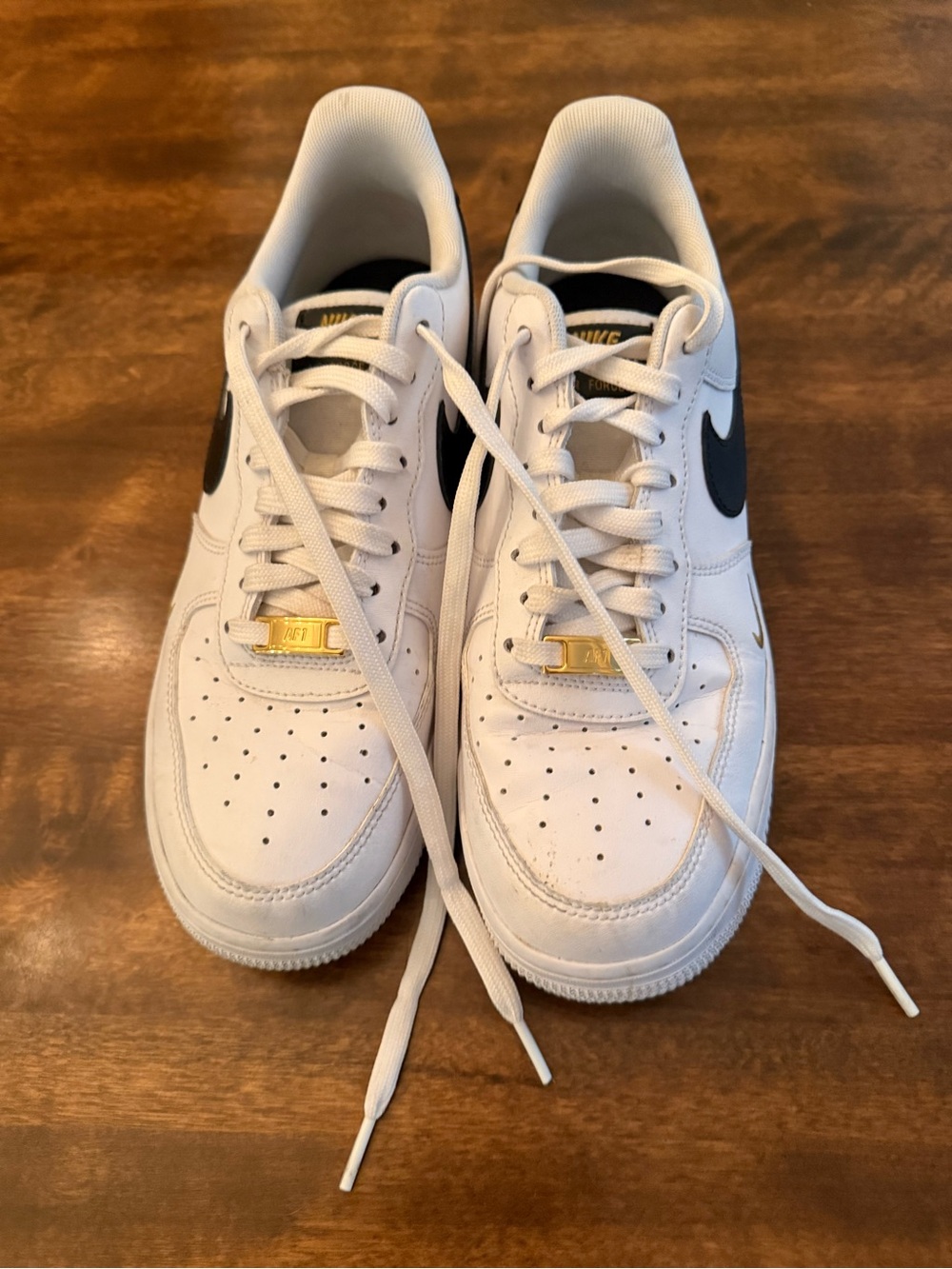 Nike White Sneakers with Black Swoosh and Gold Accents